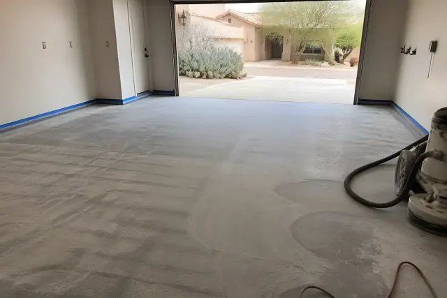 Concrete garage floor prepped with grinding marks and masking tape for epoxy coating in Casas Adobes, AZ.