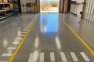 High-gloss epoxy warehouse floor with safety lines and view of Sonoran desert scrub in Tucson, AZ.