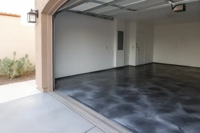 Completed metallic epoxy flake flooring in a residential garage in Tucson, AZ with desert landscaping visible outside.