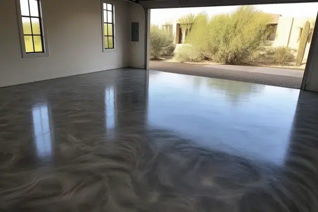 Metallic epoxy flooring in a two-car garage in Tanque Verde, AZ, with desert scenery visible through the doorway.
