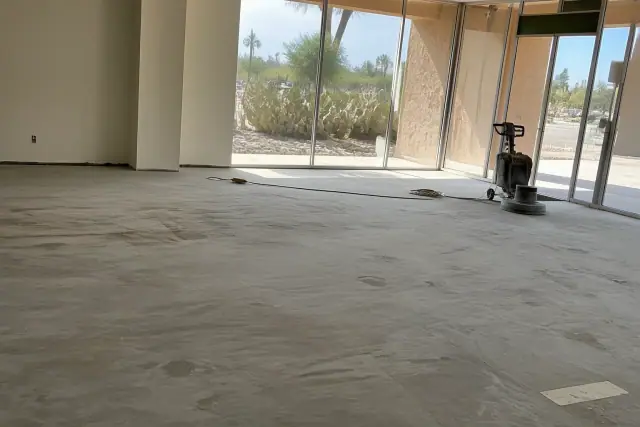 Concrete floor prepared for metallic epoxy installation in a Tucson, AZ retail showroom with desert views.