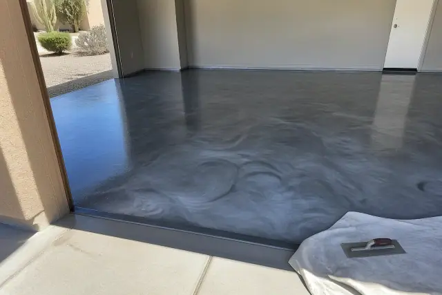 Newly applied metallic epoxy flooring in a residential garage in Marana, AZ, with a notched trowel on a drop cloth.