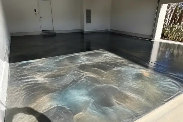Metallic epoxy garage flooring with swirling resin patterns and desert plants in a Tucson, AZ home.