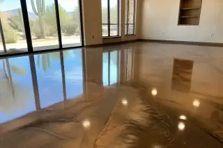 Metallic epoxy floor with swirls of color in a Tucson, AZ retail showroom showing desert plants through the glass.