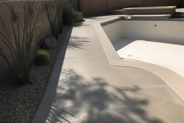 Drained swimming pool with concrete deck waiting for non-skid sealant at a home in Tucson, AZ.