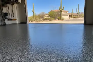 Wide shot of a finished flake epoxy garage floor with desert landscaping and stucco homes in Tucson, AZ.