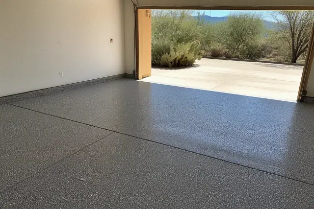 Concrete garage floor with fresh decorative flake coating and cacti visible outside in Tucson, AZ.