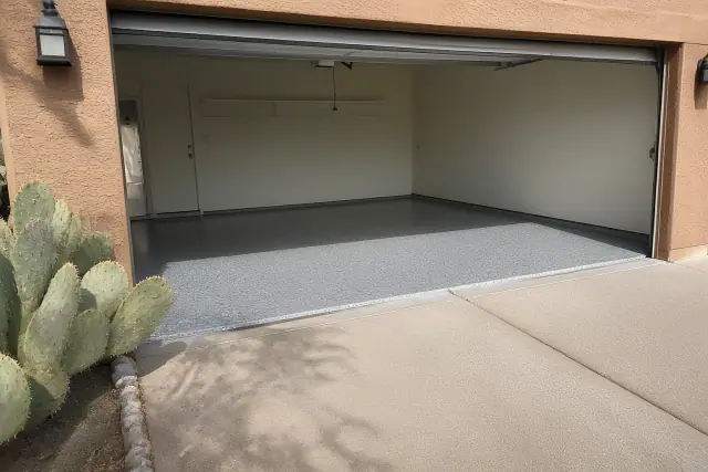 Concrete garage floor with decorative flakes and a prickly pear cactus outside a home in Tucson, AZ.