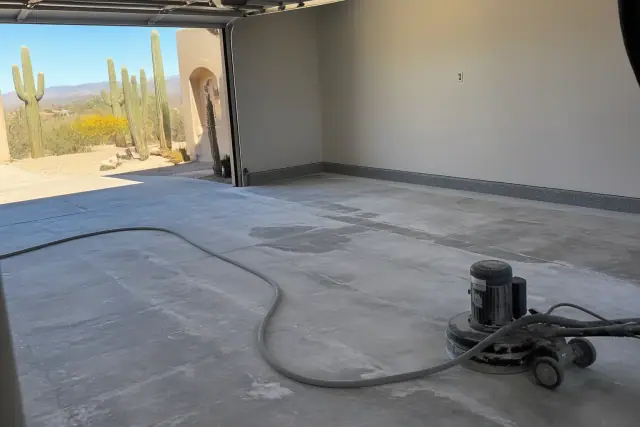 Empty two-car garage with prepped concrete floor ready for decorative flakes in Drexel Heights, AZ.