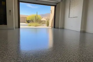 High-gloss polyaspartic garage floor in a Tucson, AZ home with a view of the Sonoran desert through the open bay door.