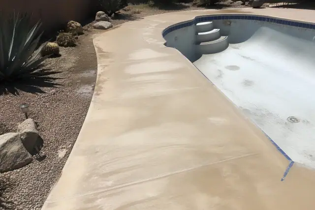 Drained swimming pool deck with concrete surfaces ready for sealant in Vail, AZ.