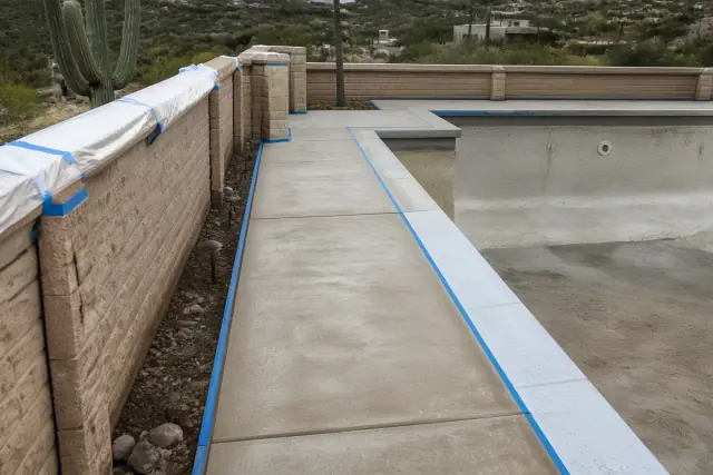 Drained swimming pool deck with concrete substrate taped off for epoxy coating in Catalina Foothills, AZ.