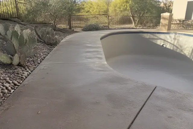 Concrete pool deck awaiting sealant with desert landscaping in Casas Adobes, AZ.