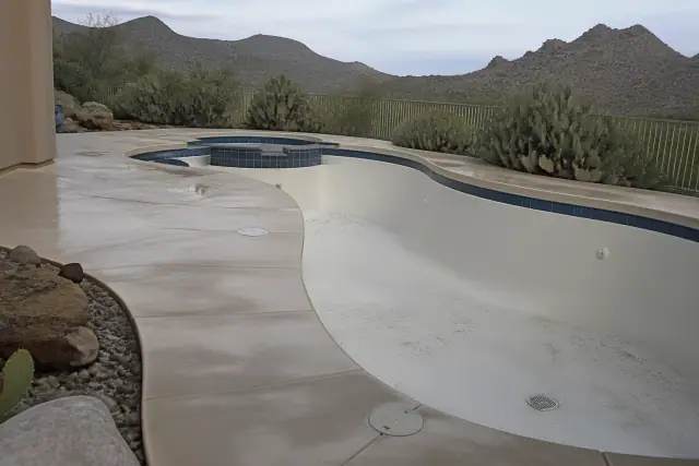 Polyaspartic floor coating on a drained pool deck in Tucson, AZ with desert mountains in the background.