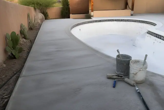 Concrete pool deck surface preparation for epoxy coating in South Tucson, AZ, with mixing buckets and rollers.