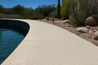 Textured anti-slip pool deck coating along a water feature in a sunny Tucson, AZ backyard.