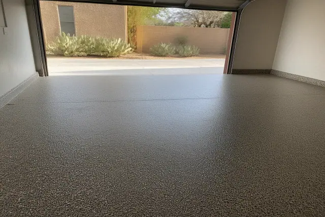 Flake epoxy garage flooring with a view of prickly pear cacti and a stucco wall in Tucson, AZ.