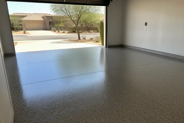 Empty two-car residential garage in Tucson, AZ with a freshly cured, high-gloss decorative flake epoxy floor.