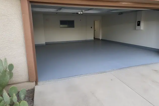 Solid-color epoxy base coat applied to a residential two-car garage floor in Tucson, AZ.