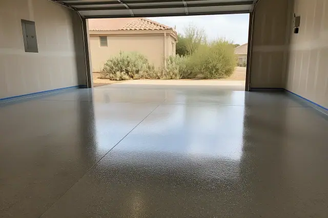 High-gloss epoxy concrete garage floor in a Tucson, AZ residence with views of prickly pear cactus outside.