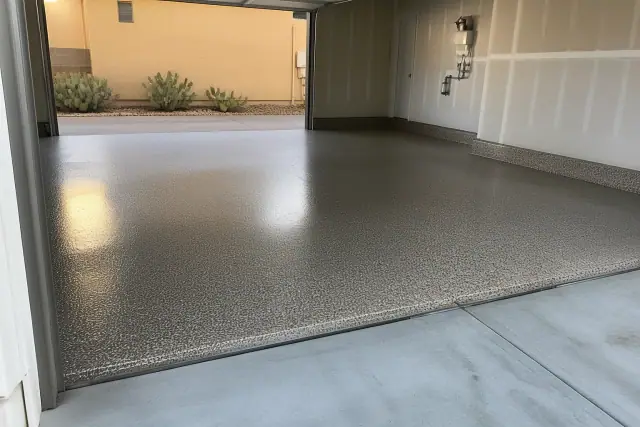 Glossy epoxy floor with decorative flakes in an empty two-car residential garage in Tucson, AZ.