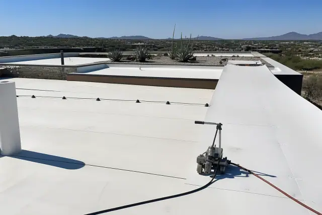 Heat-welded seams on a commercial building rooftop with desert landscaping in Tucson, AZ.