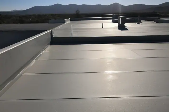 Heat-welded seams on a commercial flat roof membrane in Casas Adobes, AZ with desert foothills in the background.