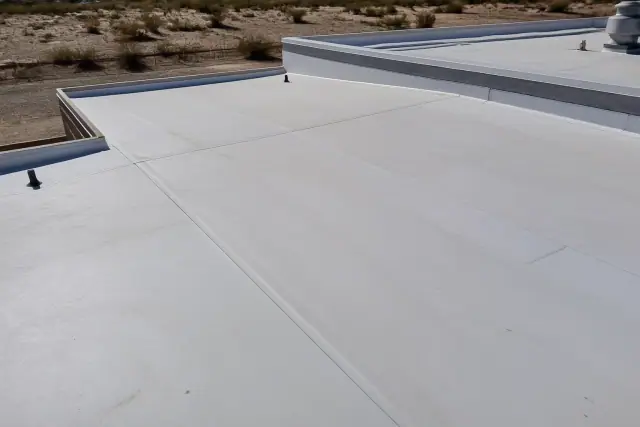 Heat-welded membrane seam on a flat commercial roof in Drexel Heights, AZ, with desert landscape in the background.