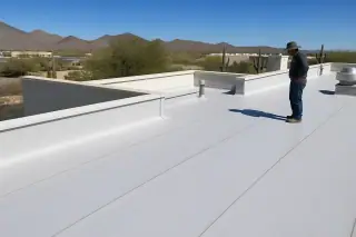 Finished heat-welded seams on a flat commercial roof with desert scrub in Tucson, AZ.