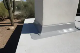 Industrial sealant applied around a chimney flashing on a residential roof in Tucson, AZ with saguaro cacti.