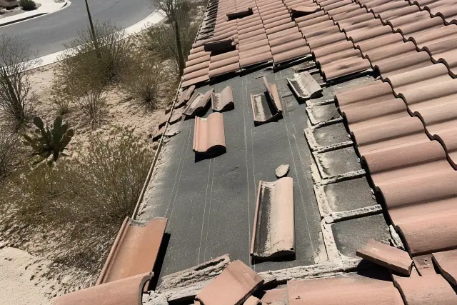Clay tiles being removed and inspected for roof repair under bright sun in Tucson, AZ.