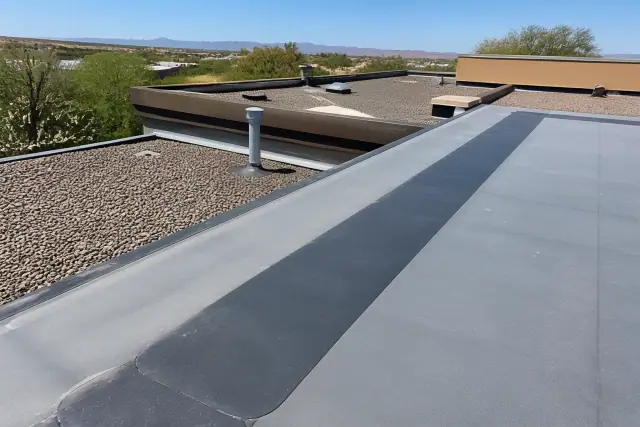 Heat-welded EPDM roof repair on a commercial building in Tucson, AZ with prickly pear cacti in the desert landscape.