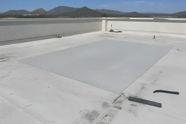 A clean rectangular membrane patch on a commercial flat roof in Tucson, AZ, with desert mountains in the background.
