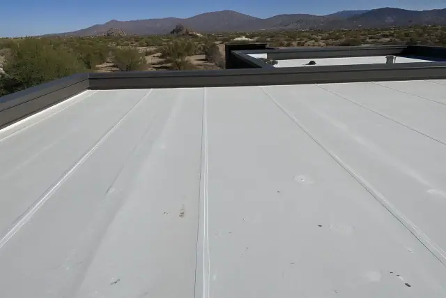 Heat-welded seams on a flat commercial roof membrane in Vail, AZ with desert mountains in the background.