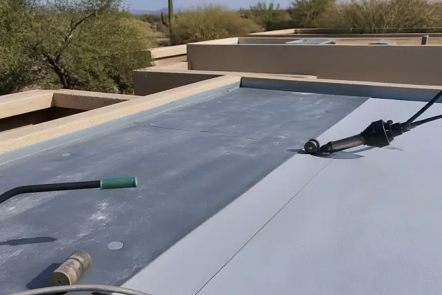 Technician applying heat-welded seams to a flat residential roof in Casas Adobes, AZ.