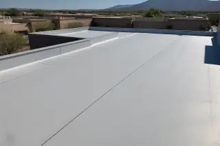 Sealed heat-welded seams on a finished flat roof with stucco buildings in the background in Tucson, AZ.