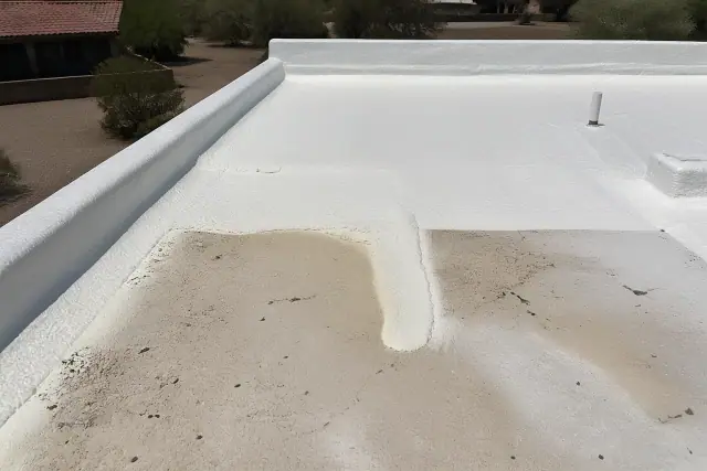 Polyurethane foam insulation being sprayed onto a residential flat roof during a repair in Tucson, AZ.