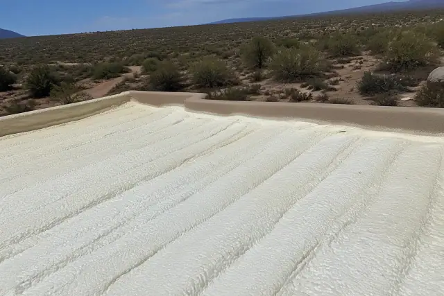Freshly applied polyurethane foam insulation on a roof deck in Vail, AZ with desert terrain in the background.