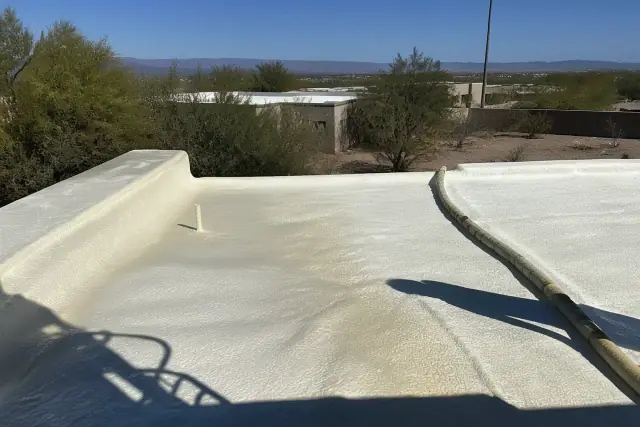 Polyurethane foam being sprayed onto a residential flat roof in Drexel Heights, AZ.