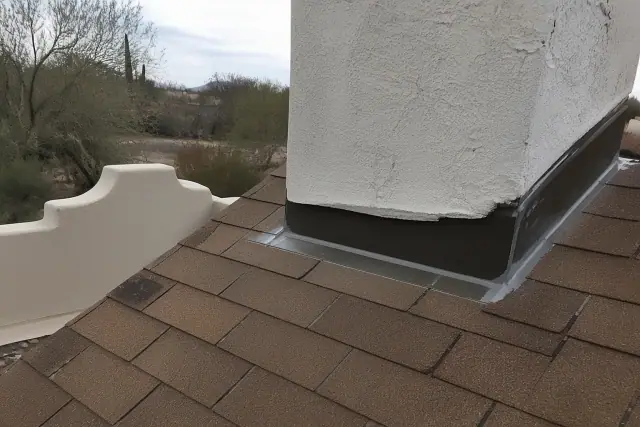 Sealant being applied to a chimney stack flashing on a stucco roof in Tucson, AZ.