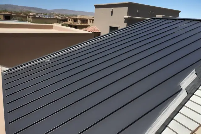 Standing seam metal panels being installed on a sloped commercial roof in Tucson, AZ.