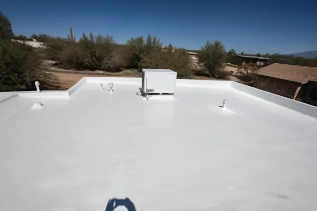 Finished reflective white roof coating on a residential home in Drexel Heights, AZ, surrounded by desert scrub.