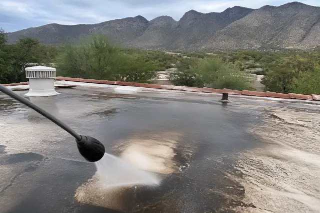 A pressure washer cleaning a weathered roof surface in Catalina Foothills, AZ.