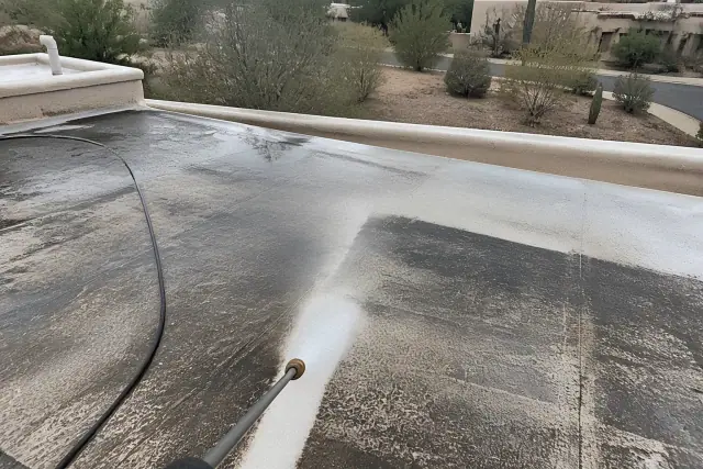 Contractor cleaning a weathered residential roof for maintenance in Tucson, AZ.