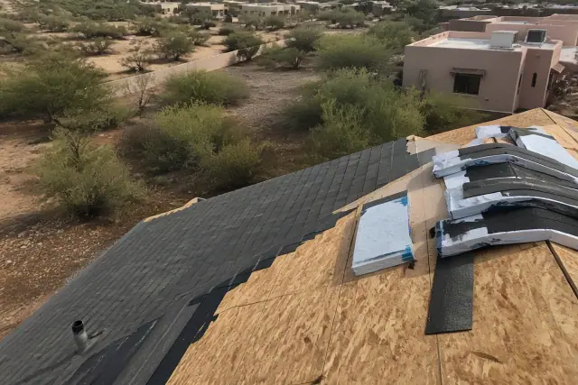 Asphalt shingles being installed on a steep residential roof in Flowing Wells, AZ.