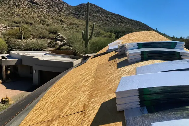 Technician installing shingles on a steep-sloped residential roof in Catalina Foothills, AZ.