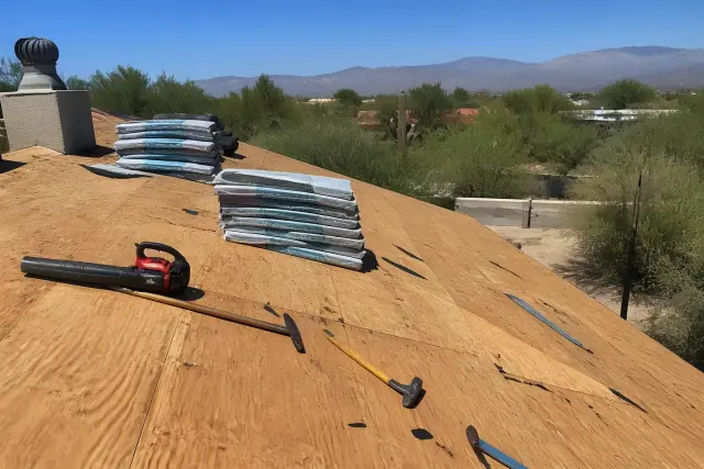 Bundles of shingles and roofing tools on a wooden roof deck during a replacement project in Tanque Verde, AZ.