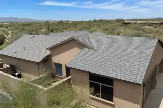 Finished residential shingle roof with clean ridge caps and desert landscape in Tucson, AZ.