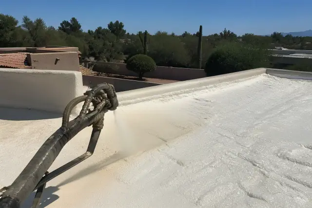 Operator applying spray polyurethane foam roofing to a residential roof in Tucson, AZ.