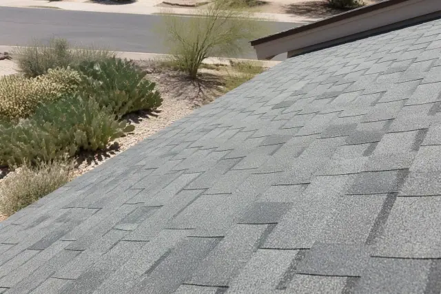 Standard three-tab shingles recently installed on a residential roof in Tucson, AZ, with prickly pear cacti nearby.